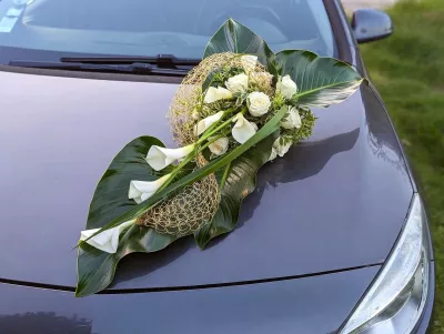 Modern wedding car decoration for Cynthia's wedding, featuring white calla lilies, roses and lush green foliage.