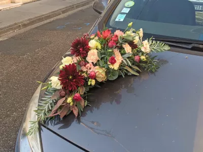 Decoration florale champetre pour voiture de mariage, avec dahlias bordeaux, roses creme et feuillage vert eucalyptus, mariage au Chateau de Garde.