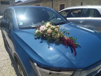Décoration florale de voiture champêtre avec roses, amarante et feuillage pour un mariage d'été