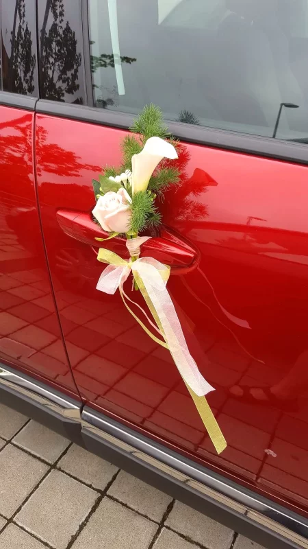 Décoration florale de poignée de voiture style classique avec une rose crème, un arum blanc et du feuillage vert.