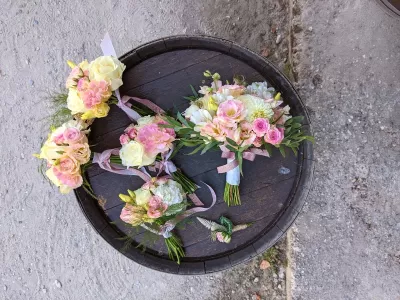 Ensemble floral champêtre pour mariage avec bouquet de mariée, bouquets de demoiselles et boutonnière, aux teintes de blanc, rose et vert.