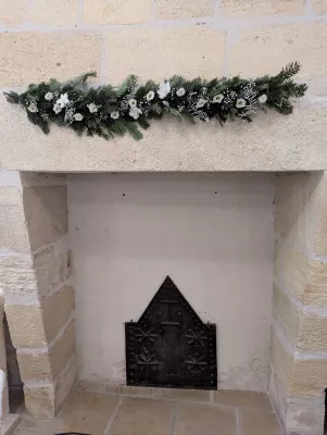 Guirlande de cheminée classique avec sapin, fleurs blanches et accents givrés pour une décoration de mariage hivernal.