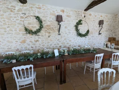 Guirlande florale champêtre en eucalyptus et gypsophile, décorant une longue table de mariage en bois.