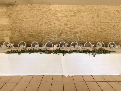 Guirlande florale champêtre pour table d'honneur avec eucalyptus et mini-roses pâles, au mariage du Domaine de Valmont.