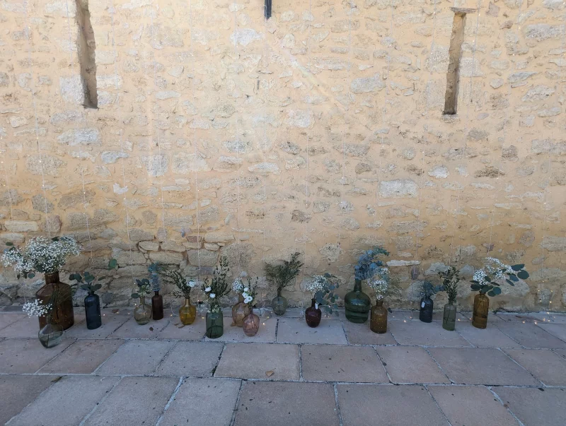 Hanging mini-vases with gypsophila and eucalyptus, a wall display for a wedding photo corner.