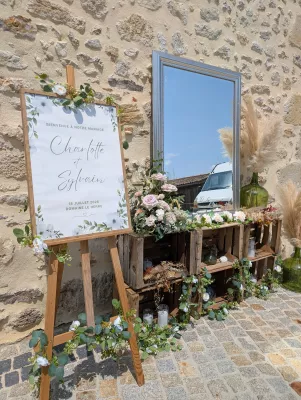 Floral welcome sign with eucalyptus and roses, sophisticated country-style decor for a wedding.