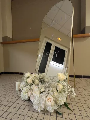 Welcome sign with floral arrangement of hydrangeas, roses, and gypsophila for Camille and Rémi's wedding.