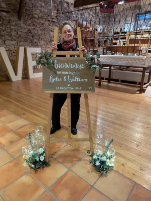 Panneau de bienvenue décoré de verdure de sapin, fleurs blanches et éléments givrés pour le mariage de Lydie et William.