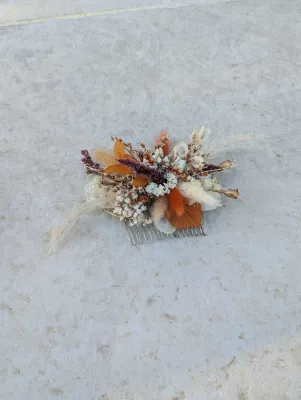 Bridal comb with dried flowers in shades of orange, terracotta, and burgundy for a rustic wedding.