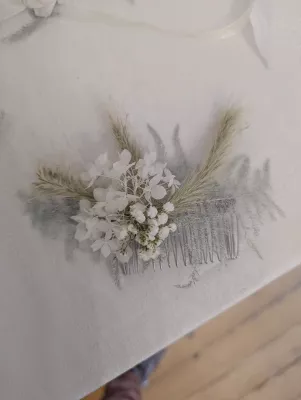 Sophisticated country-style floral comb with white hydrangeas and gypsophila for a bridal hairstyle.