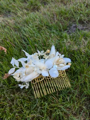 Peigne de mariée bohème avec hortensias séchés blancs, petites fleurs et feuillages pour un mariage délicat.