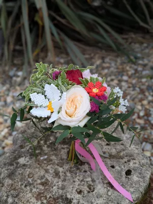 Petit bouquet pour témoin ou enfant, avec roses, feuillage varié et créations originales en perles : marguerite et fraise.