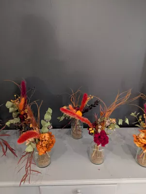 Small bohemian bouquets with dried orange flowers and foliage, perfect for bridesmaids or flower children.