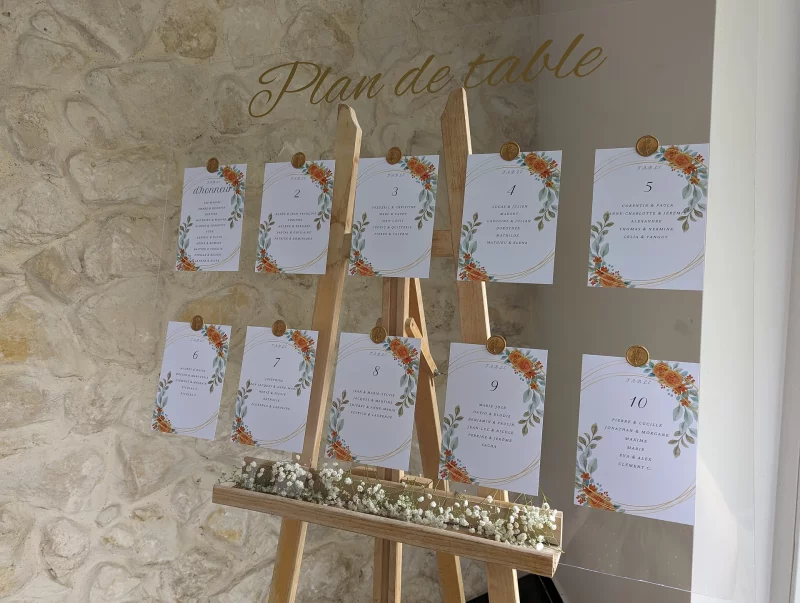 Presentation of the seating plan on a wooden easel, elegantly adorned with gypsophila at its base for a wedding.