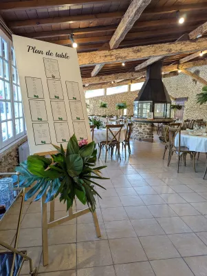 Plan de table de mariage décoré avec une composition luxuriante de feuilles de monstera et de feuillage tropical vert.