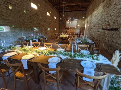 Vue d'ensemble de la salle de réception avec des centres de table champêtres verdoyants pour le mariage.