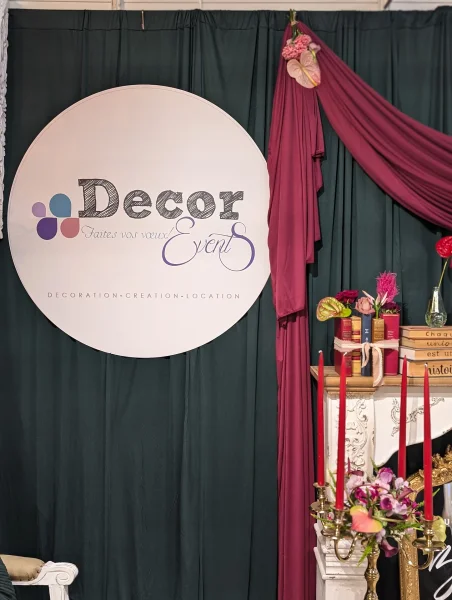 Scénographie d'événement avec logo 'Decor Events', drapés sombres et chandelier avec chandelles rouges, ambiance classique.