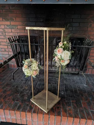 Scenographie florale pour mariage avec compositions sur supports en bois, roses et hydrangeas, style classique.