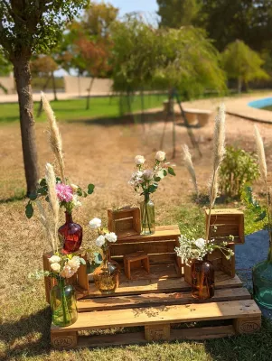 Scénographie mariage bohème avec pampa, roses, eucalyptus et cagettes en bois pour photobooth