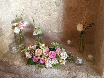 Scénographie bohème pour mariage avec roses, hortensias et marguerites, complétée par des bougies tamisées.