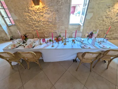 Long top table with floral centrepieces and coloured candles, sophisticated rustic style.