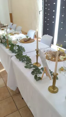 Eucalyptus garland and cream roses on a sophisticated country-style head table for a wedding.