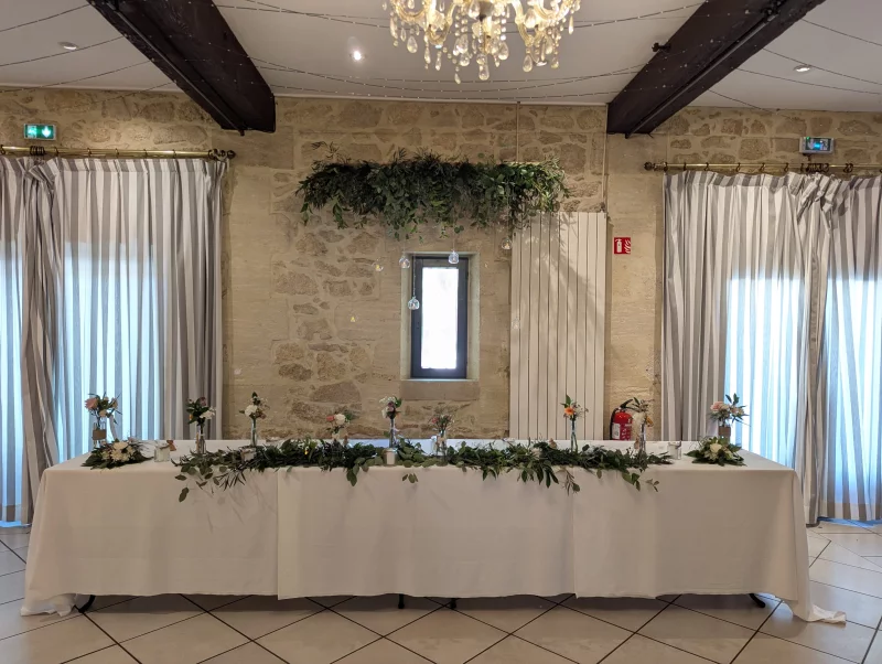 Head Table adorned with an eucalyptus and ruscus garland, accented with small floral arrangements.