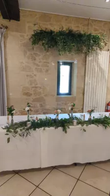 Table d'honneur végétalisée avec guirlande d'eucalyptus et ruscus, agrémentée de petites compositions florales.