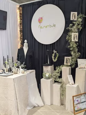 Decoration table d'honneur minimaliste avec gypsophile, feuillage vert et colonnes decoratives blanches.