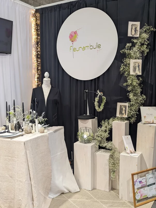 Decoration table d'honneur minimaliste avec gypsophile, feuillage vert et colonnes decoratives blanches.