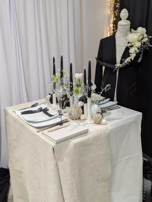 Table d'honneur minimaliste avec gypsophile, bougies noires, une rose blanche et decoration de veste.