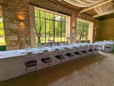 Aménagement de table d'honneur avec centres de table hauts d'hortensias, glaïeuls et feuillages, style champêtre élégant.