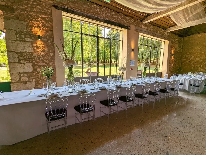 Aménagement de table d'honneur avec centres de table hauts d'hortensias, glaïeuls et feuillages, style champêtre élégant.