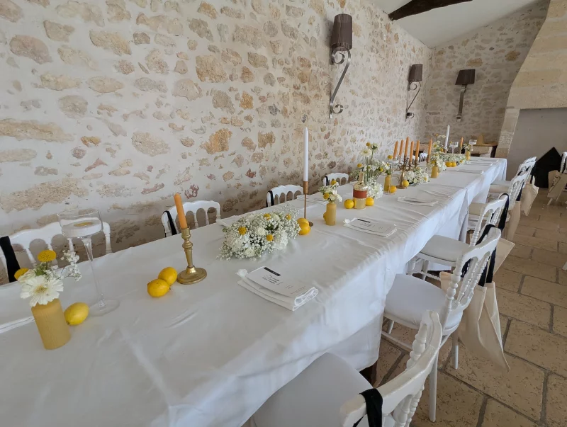 A long wedding top table adorned with white gerberas, yellow craspedias and lemons for a rustic charm.