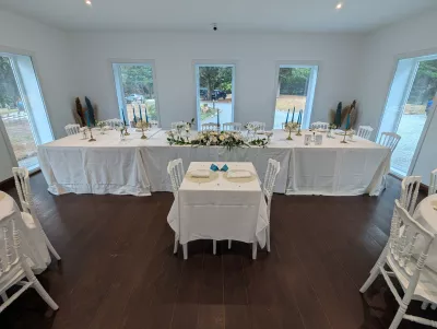 Sophisticated country wedding reception hall with head tables, orchids, and blue candles.