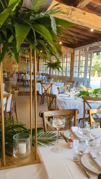 Décoration de table d'honneur avec centres de table hauts et une guirlande de feuillage tropical pour un mariage exotique.