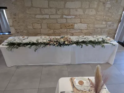 Wedding Head Table featuring an elongated floral centrepiece of roses, eucalyptus, and pampas grass.