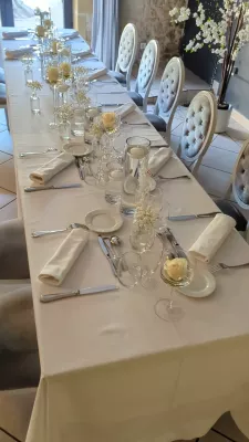 Décoration de table d'honneur élégante pour un mariage, avec roses blanches simples dans des petits vases.