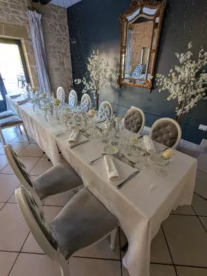 Décoration de table d'honneur élégante pour un mariage, avec roses blanches simples dans des petits vases.