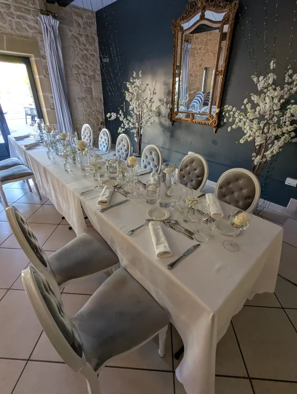 Elegant top table decoration for a wedding, with simple white roses in bud vases.