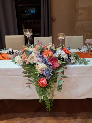 Sophisticated rustic head table with roses, carnations, hydrangeas, and eucalyptus.