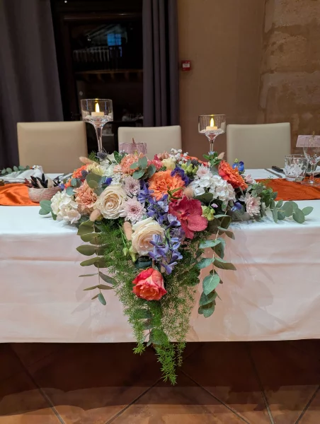 Table d'honneur champêtre sophistiquée avec roses, œillets, hortensias et eucalyptus.