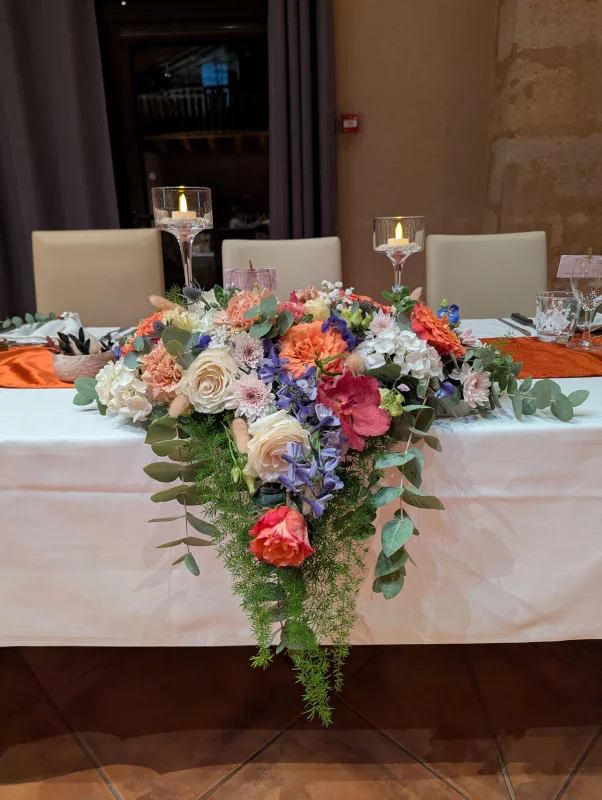 Sophisticated rustic head table with roses, carnations, hydrangeas, and eucalyptus.