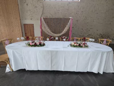 Table d'honneur romantique organique avec compositions florales et bougies flottantes pour mariage.