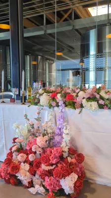 Sophisticated country-style head table with roses, hydrangeas, delphiniums, and alstroemerias.