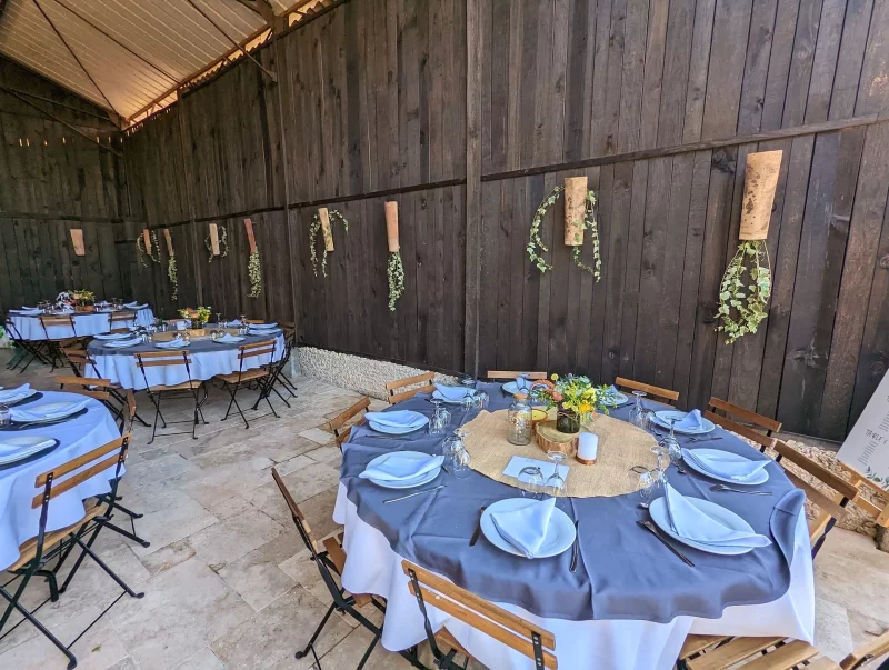 Table de mariage champêtre au Moulin de Laboirie avec centre de table tournesol et chardon.
