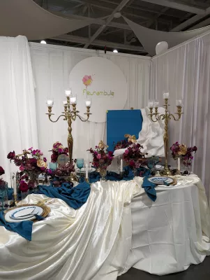 Décoration de table d'honneur classique avec compositions florales bordeaux, orchidées magenta et touches dorées pour un salon du mariage.