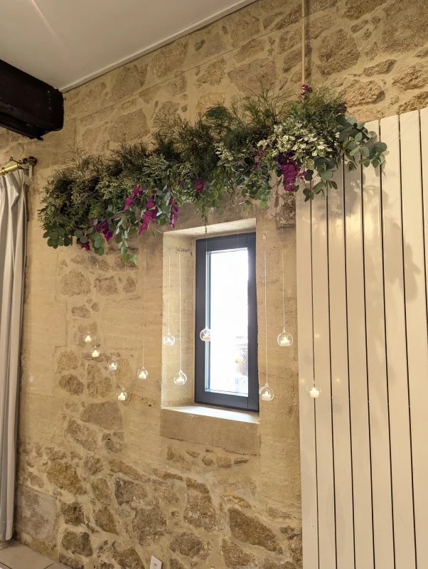 Végétalisation suspendue avec eucalyptus et touches de fleurs violettes pour décoration intérieure.