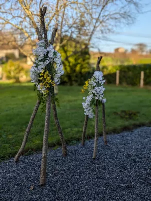 Décorations extérieures champêtres pour mariage d'hiver avec branches naturelles, fleurs blanches et jaunes et fougères.