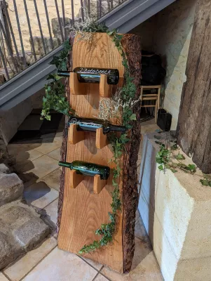 Décoration champêtre de stand en bois avec guirlande de lierre luxuriante et touches de gypsophile blanc pour un mariage.